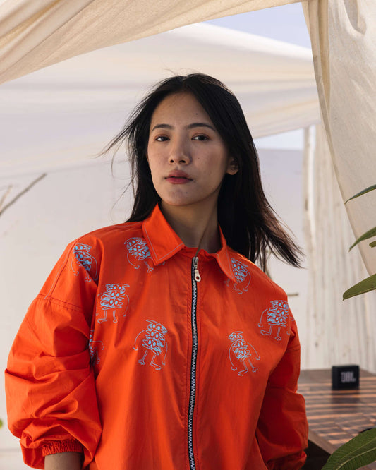Orange embroidered shirt with floral detailing styled in a contemporary outdoor setting